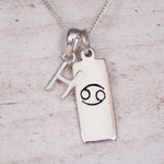 Sterling Silver H Initial Cancer Zodiac Star Sign Necklace on a fine silver chain against a light wooden background