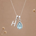 Sterling silver H initial necklace with pale blue March aquamarine in a polished teardrop bezel