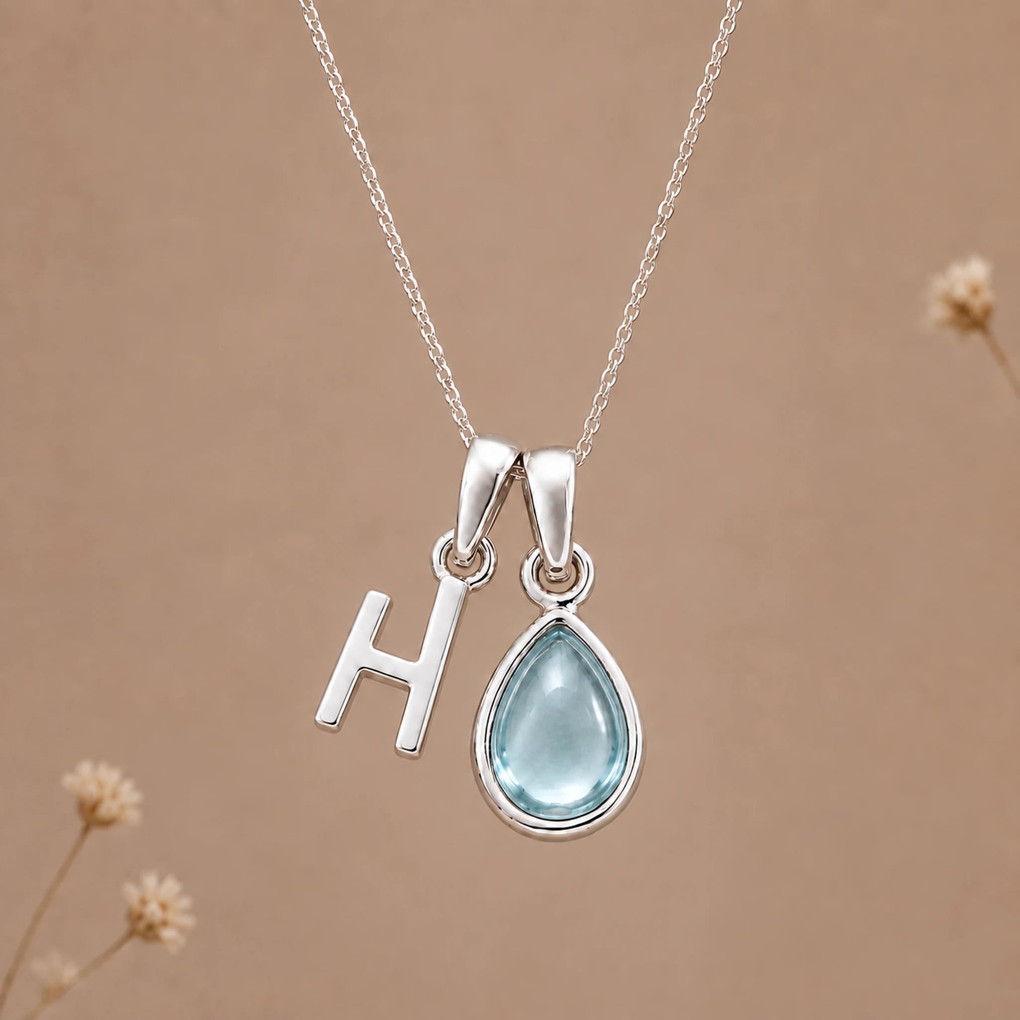 Sterling silver H initial necklace with pale blue March aquamarine in a polished teardrop bezel