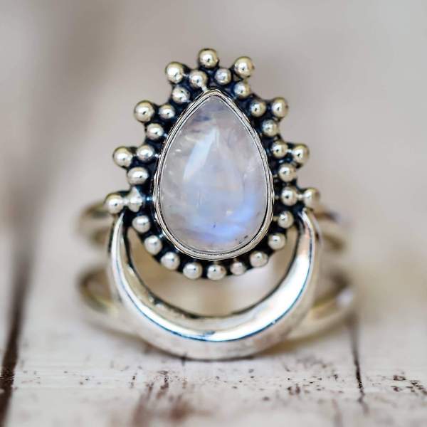 sterling Silver moonstone ring with a teardrop-shaped moonstone gemstone on a wooden surface 