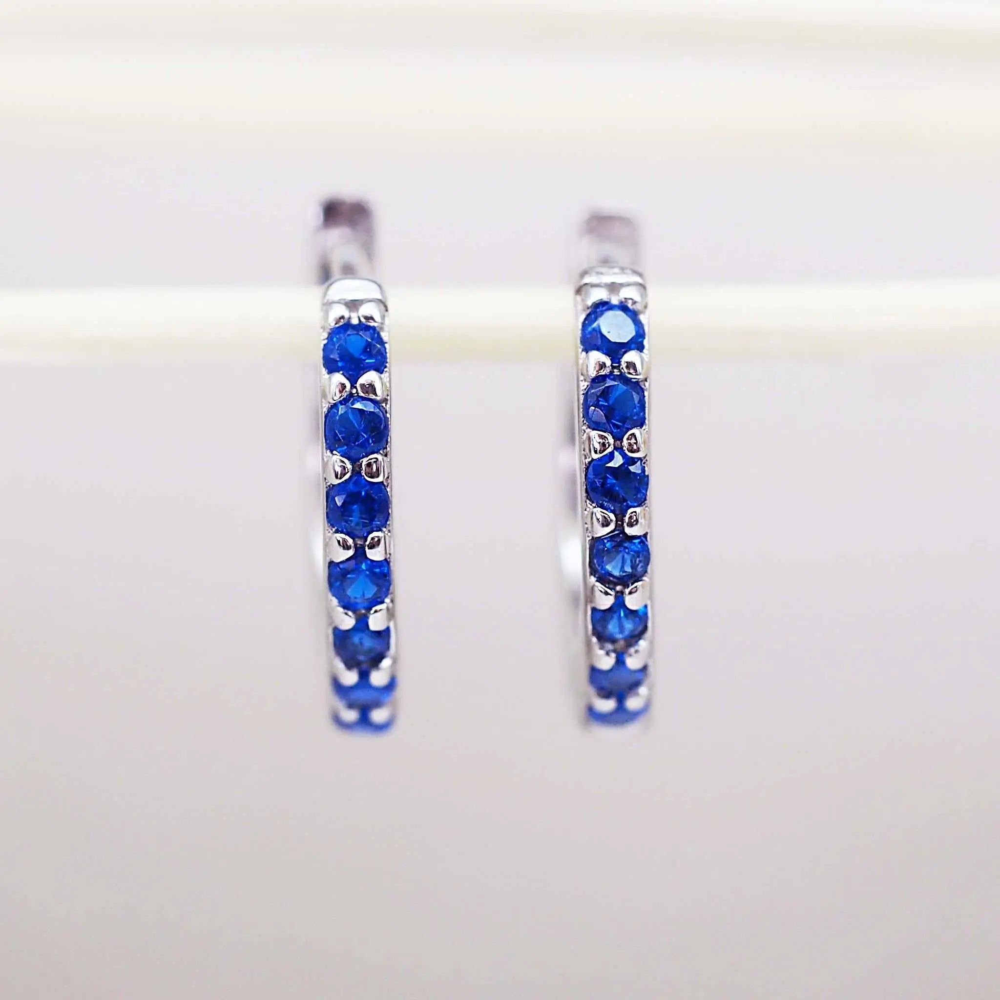 Sterling Silver huggie earrings with blue cubic zirconias