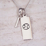 Sterling Silver I Initial Cancer Zodiac Star Sign Necklace on a fine silver chain against a light wooden background