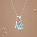 Sterling silver I initial necklace with pale blue March aquamarine in a polished teardrop bezel