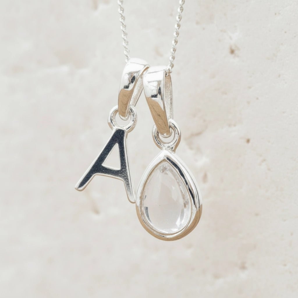 Sterling Silver 'A' Initial Necklace with a tear drop shaped April Birthstone Herkimer Quartz Pendant on a white background.