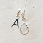Sterling Silver 'A' Initial Necklace with a tear drop shaped April Birthstone Herkimer Quartz Pendant on a white background.
