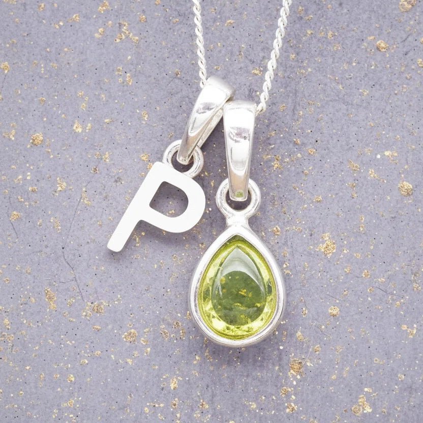 Sterling Silver 'P' Initial Necklace with a pear-shaped cabochon August Birthstone Peridot Pendant on a grey background