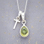 Sterling Silver 'T' Initial Necklace with a pear-shaped cabochon August Birthstone Peridot Pendant on a grey background