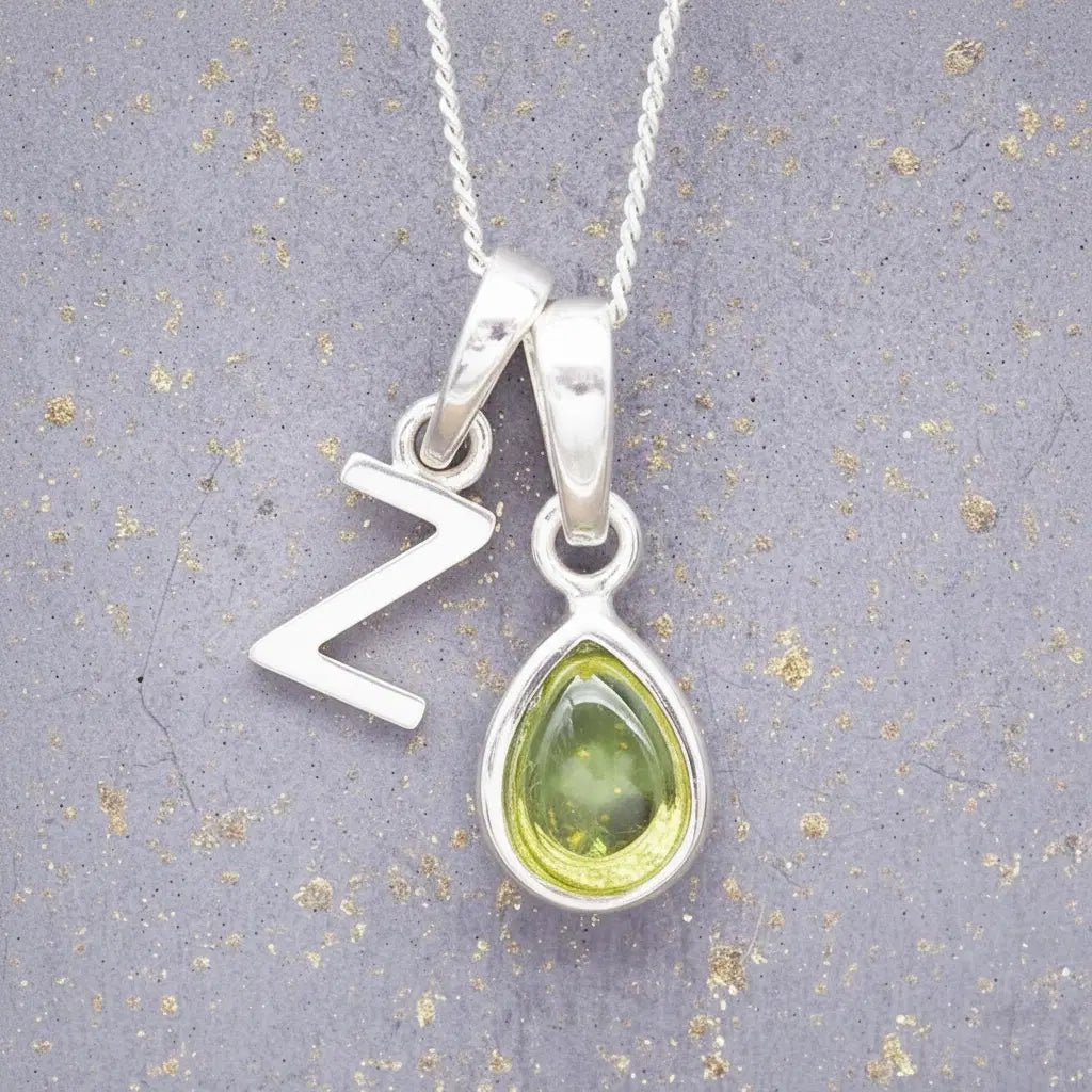 Sterling Silver 'Z' Initial Necklace with a pear-shaped cabochon August Birthstone Peridot Pendant on a grey background