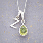 Sterling Silver 'Z' Initial Necklace with a pear-shaped cabochon August Birthstone Peridot Pendant on a grey background
