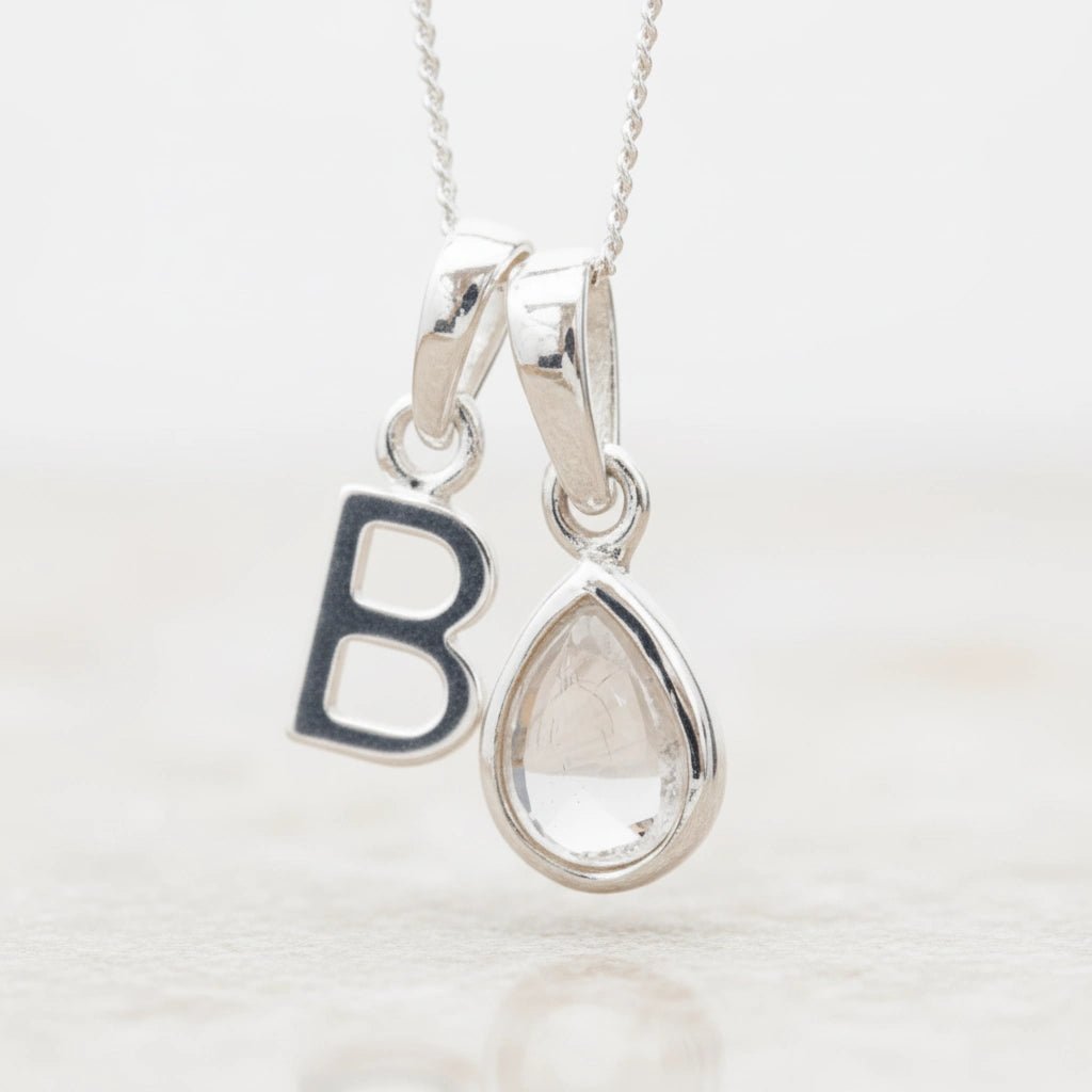 Sterling Silver 'B' Initial Necklace with a tear drop shaped April Birthstone Herkimer Quartz Pendant on a white background.