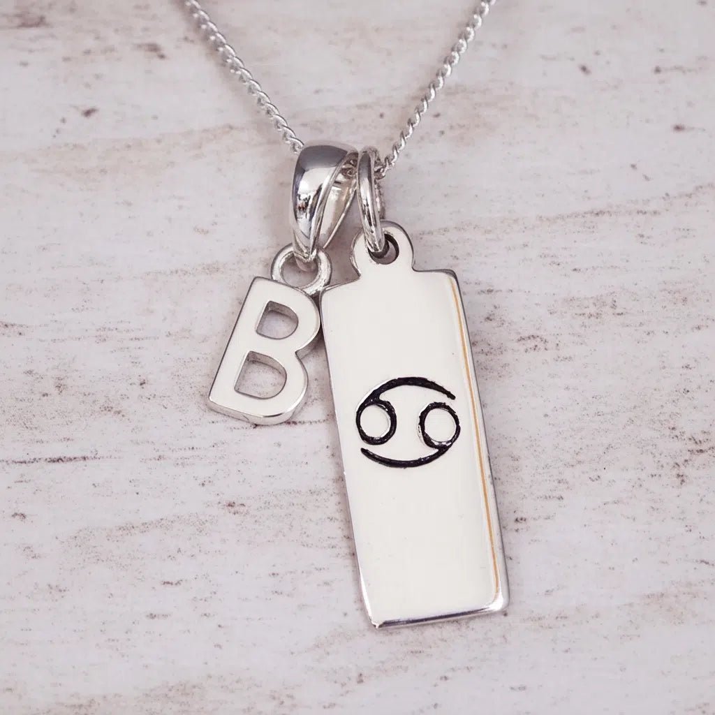 Indie and Harper personalised silver Cancer zodiac necklace with a hand-carved star sign symbol and 'B' initial charm on a 925 sterling silver necklace chain