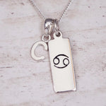 Indie and Harper personalised silver Cancer zodiac necklace with a hand-carved star sign symbol and 'C'initial charm on a 925 sterling silver necklace chain