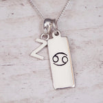 Sterling Silver necklace with 'Z' initial pendant and Cancer Zodiac pendant on a textured grey background.