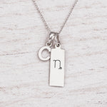Silver Initial and Capricorn Zodiac Necklace with sterling silver letter C pendant on light wood