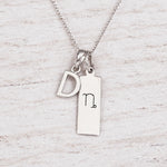 Silver Initial and Capricorn Zodiac Necklace with sterling silver letter D pendant on light wood