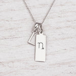 Silver Initial and Capricorn Zodiac Necklace with sterling silver letter L pendant on light wood