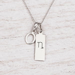 Silver Initial and Capricorn Zodiac Necklace with sterling silver letter O pendant on light wood