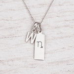 Silver Initial and Capricorn Zodiac Necklace with sterling silver letter W pendant on light wood