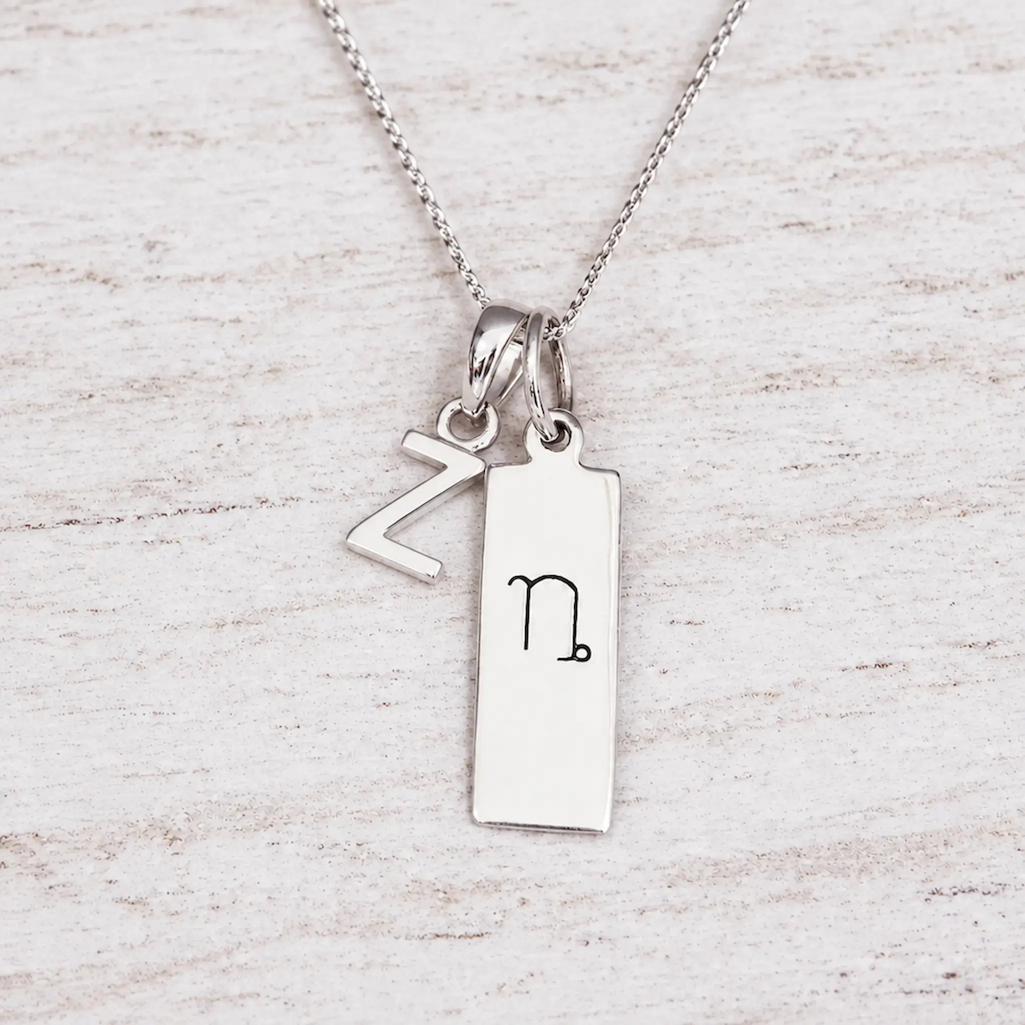 Silver Initial and Capricorn Zodiac Necklace with sterling silver letter Z pendant on light wood