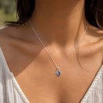 sterling silver necklace with an initial A pendant and teardrop December Birthstone Tanzanite Necklace worn on a person