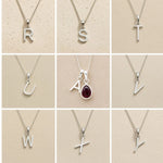 Collection of silver letter pendants r, s, t, u, a, v, w, x, y on a beige background as personalised initial options for a January Birthstone Natural Garnet Gemstone Necklace.
