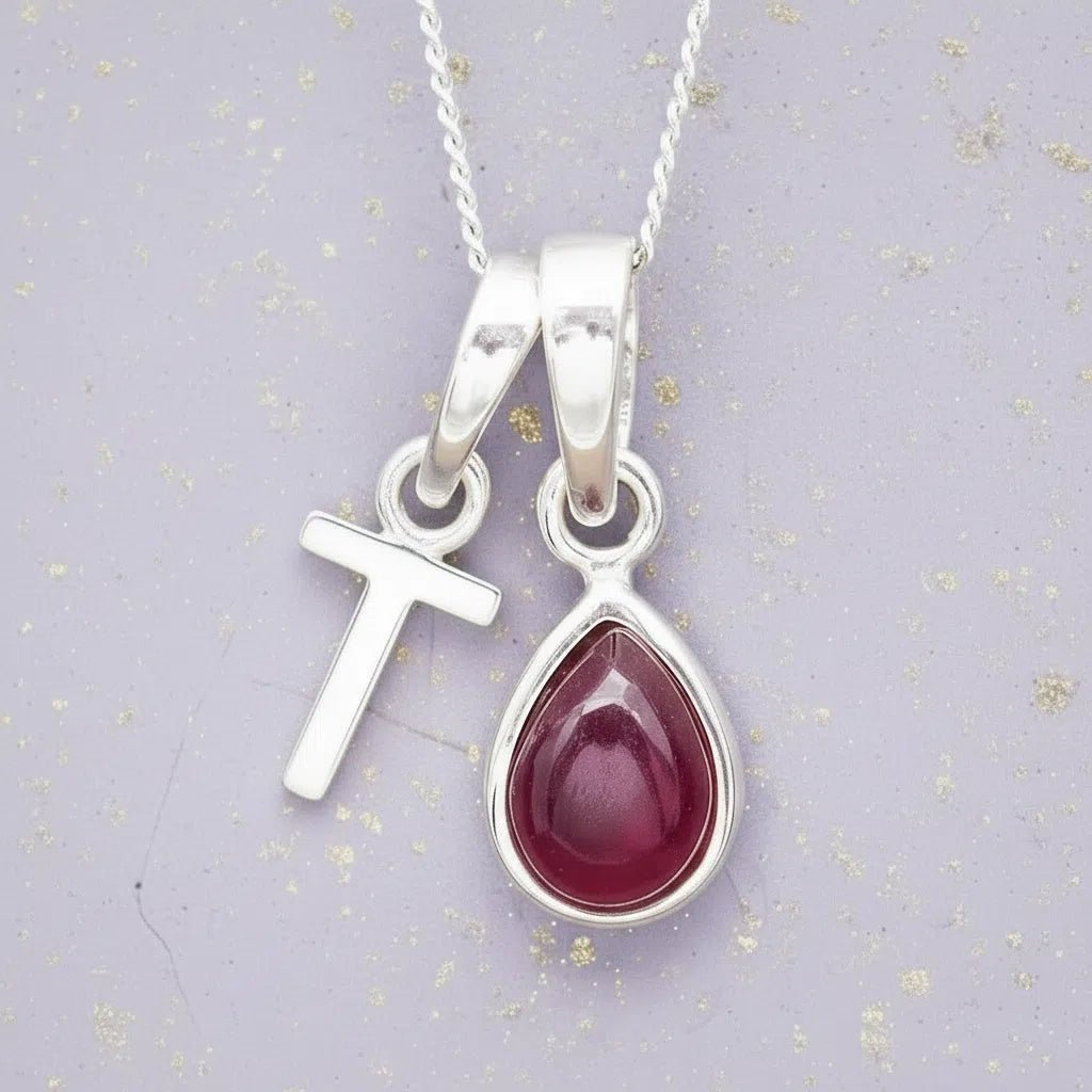 Sterling Silver necklace with 'T' initial pendant and July Birthstone Ruby gemstone pear-shaped pendant on a grey background.