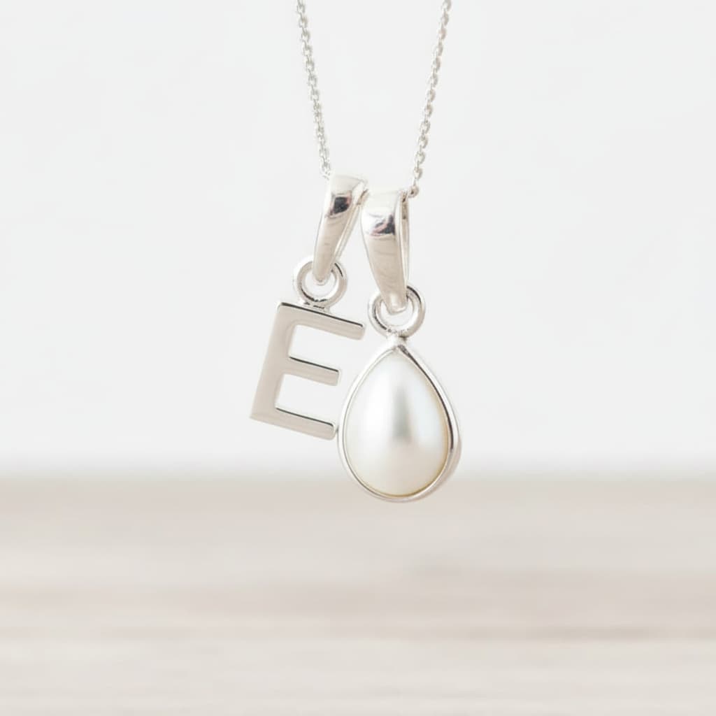 Sterling Silver necklace with 'E' initial pendant and teardrop-shaped June Birthstone mother of pearl pendant on a light background