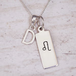 Sterling Silver necklace with a Leo Zodiac Star Sign pendant and a initial 'D' letter pendant on a light wooden background.