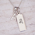 Sterling Silver necklace with a Leo Zodiac Star Sign pendant and a initial 'A' letter pendant on a wooden background.