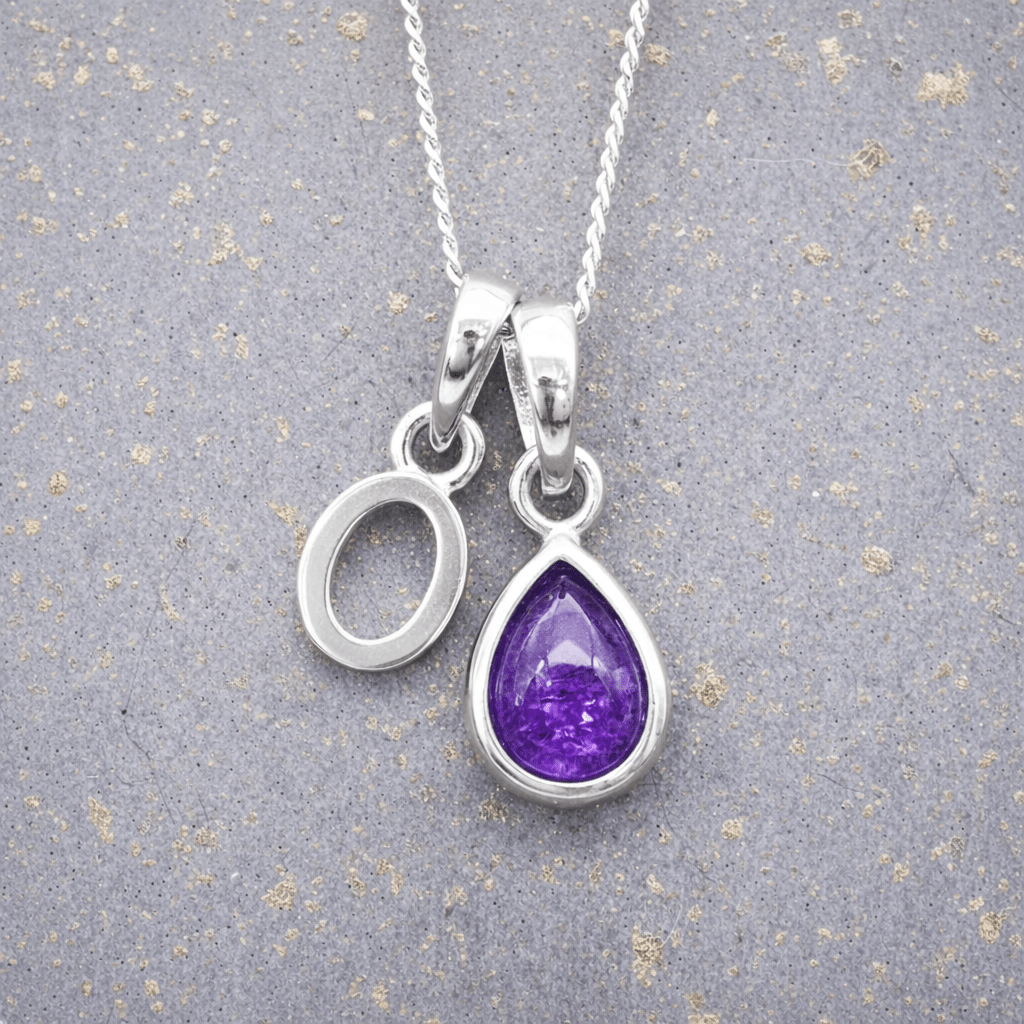 sterling Silver necklace with a 'O' initial pendant and a purple teardrop february birthstone amethyst pendant on a textured grey background