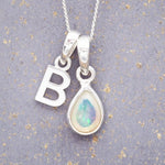 Sterling Silver necklace with 'B' initial pendant and pear-shaped October Birthstone Opal gemstone on a grey background.