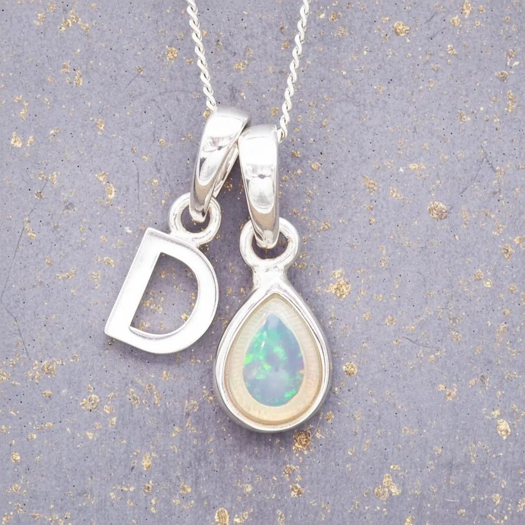 Sterling Silver necklace with 'D' initial pendant and pear-shaped October Birthstone Opal gemstone on a grey background.