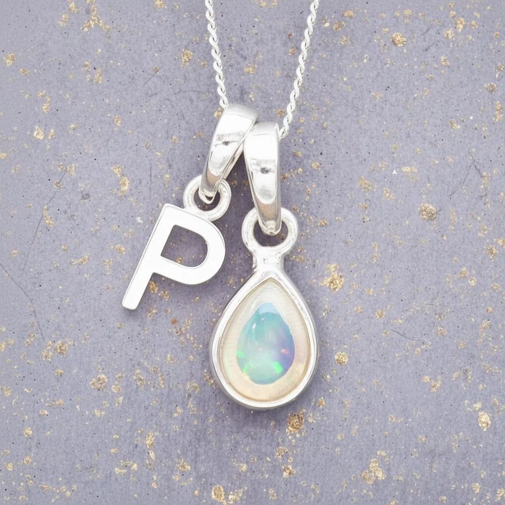Sterling Silver necklace with 'P' initial pendant and white teardrop October Birthstone Opal gemstone on a grey background.