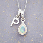 Sterling Silver necklace with 'P' initial pendant and white teardrop October Birthstone Opal gemstone on a grey background.