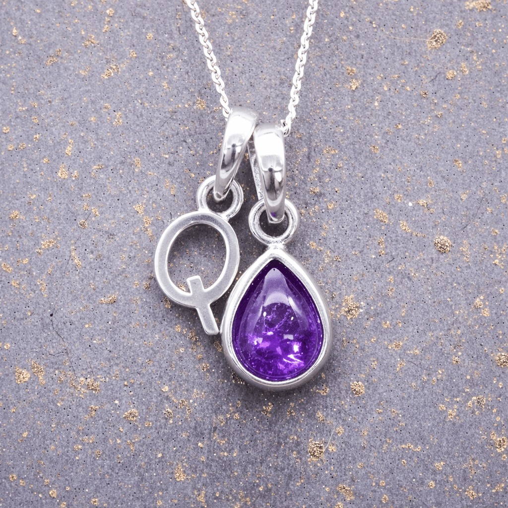 sterling Silver necklace with a 'Q' initial pendant and a purple teardrop february birthstone amethyst pendant on a textured grey background
