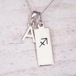 Silver necklace with a pendant featuring an 'A' and a sagittarius zodiac pendant on a light background