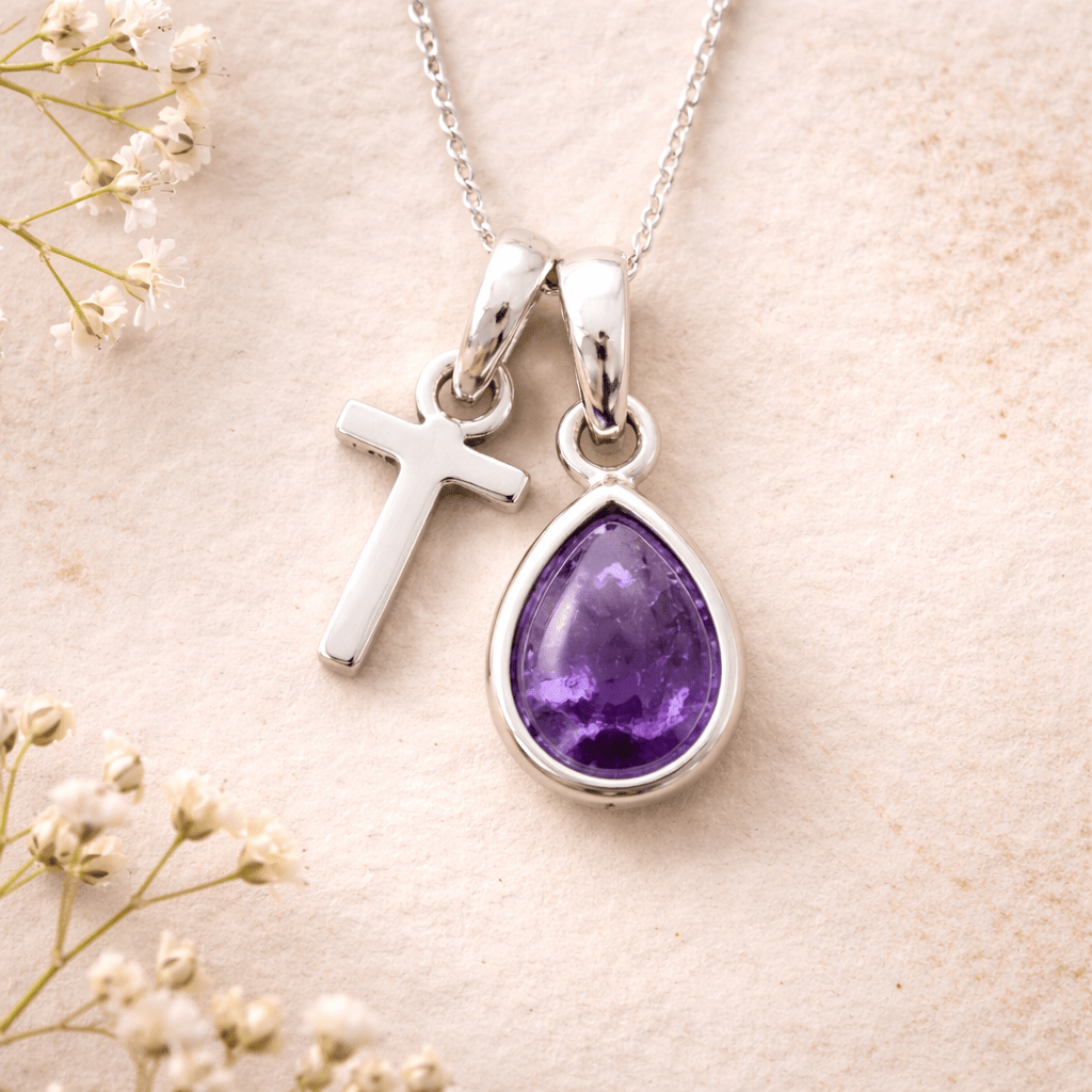 sterling Silver necklace with a 'T' initial pendant and teardrop-shaped purple february birthstone amethyst gemstone on a light background.