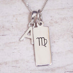 Silver necklace with a pendant featuring the letter 'A' and a Virgo zodiac symbol pendant on a light background