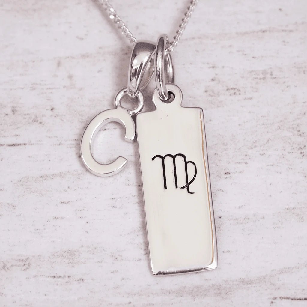 Silver ‘C’ initial pendant necklace with a pendant featuring a Virgo zodiac symbol on a light background