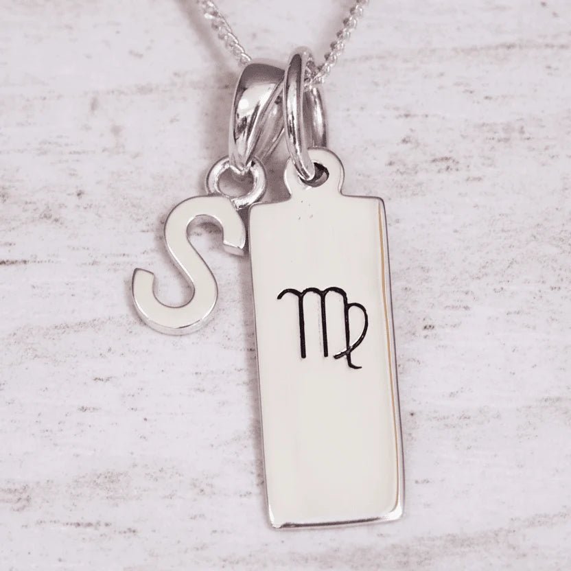 Silver ‘S’ initial pendant necklace with a pendant featuring a Virgo zodiac symbol on a light background