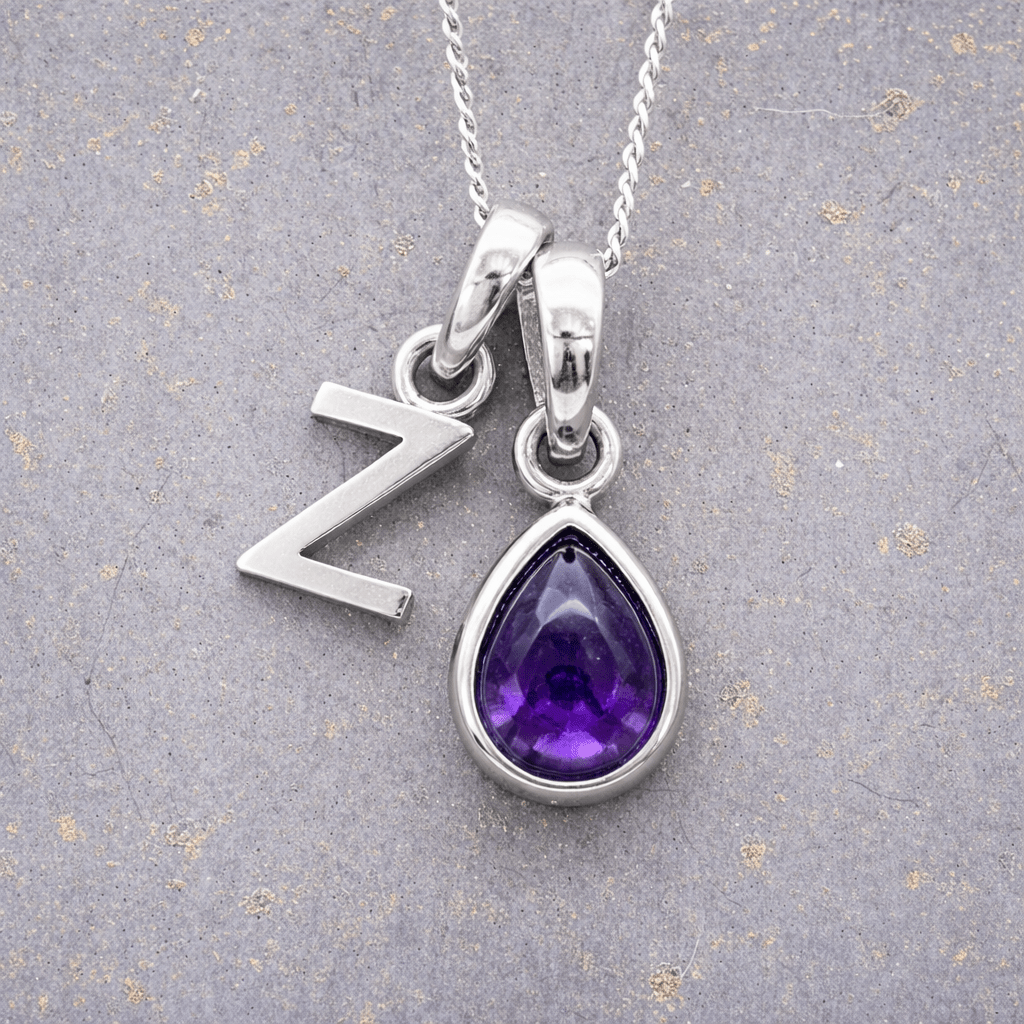 sterling Silver necklace with a 'Z' initial pendant and a purple teardrop february birthstone amethyst pendant on a textured grey background