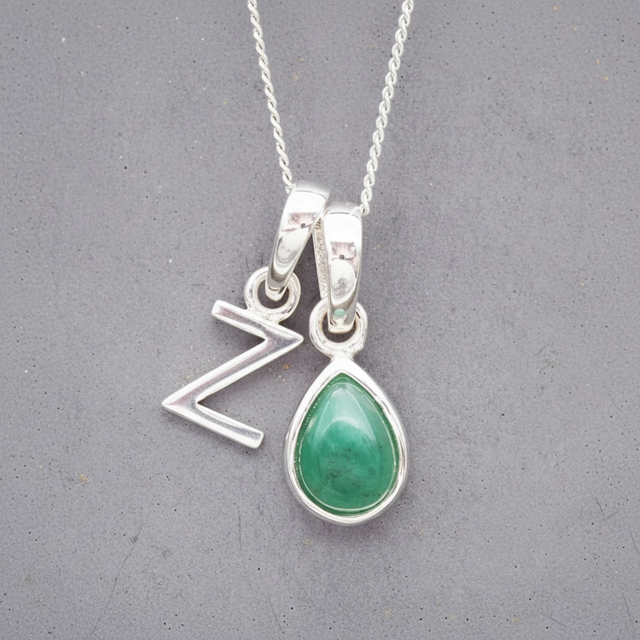 Sterling Silver double pendant necklace with a green teardrop may birthstone emerald pendant and a uppercase Z letter pendant on a grey background