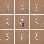 Collection of silver necklaces with initial pendant J to Q on a beige background as personalised letter options to add to a February Birthstone Amethyst Necklace.