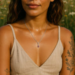 Woman wearing a silver garnet necklace in a natural setting