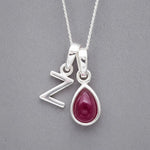 Sterling Silver double pendant necklace with a capital Z pendant and a teardrop-shaped july birthstone ruby gemstone on a grey background