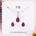 Silver Jewelry set with teardrop-shaped ruby gemstones on a display card with 'i+h' branding.