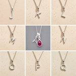 Collection of silver letter pendants J to Q on beige and grey backgrounds as personalised initial pendant options for July Birthstone Ruby Necklace.