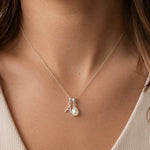 close up of a woman wearing a Sterling Silver double pendant necklace with a teardrop-shaped June birthstone Mother of Pearl pendant and letter 'A' charm 
