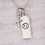 Sterling Silver K Initial Cancer Zodiac Star Sign Necklace on a fine silver chain against a light wooden background