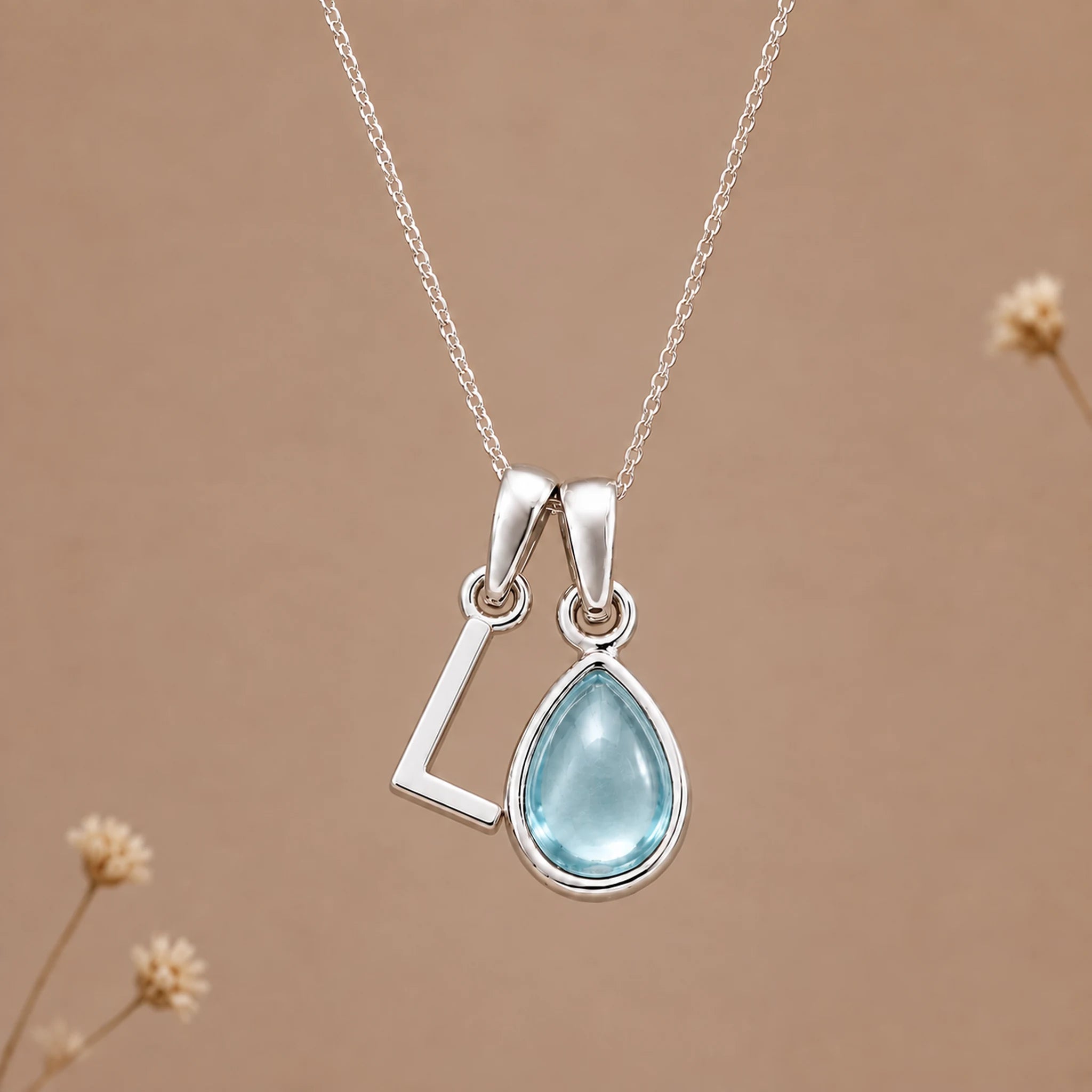 Sterling silver L initial necklace with pale blue March aquamarine in a polished teardrop bezel